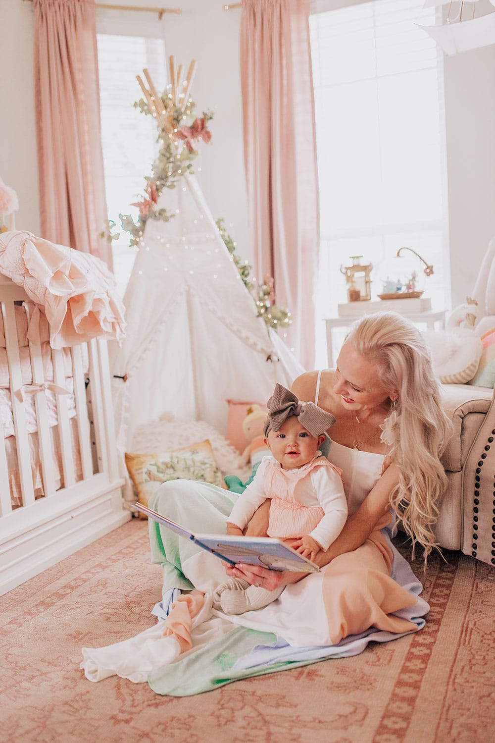 family photo ideas - mommy and me photography tips and poses - photoshoot in girl's nursery sitting with book