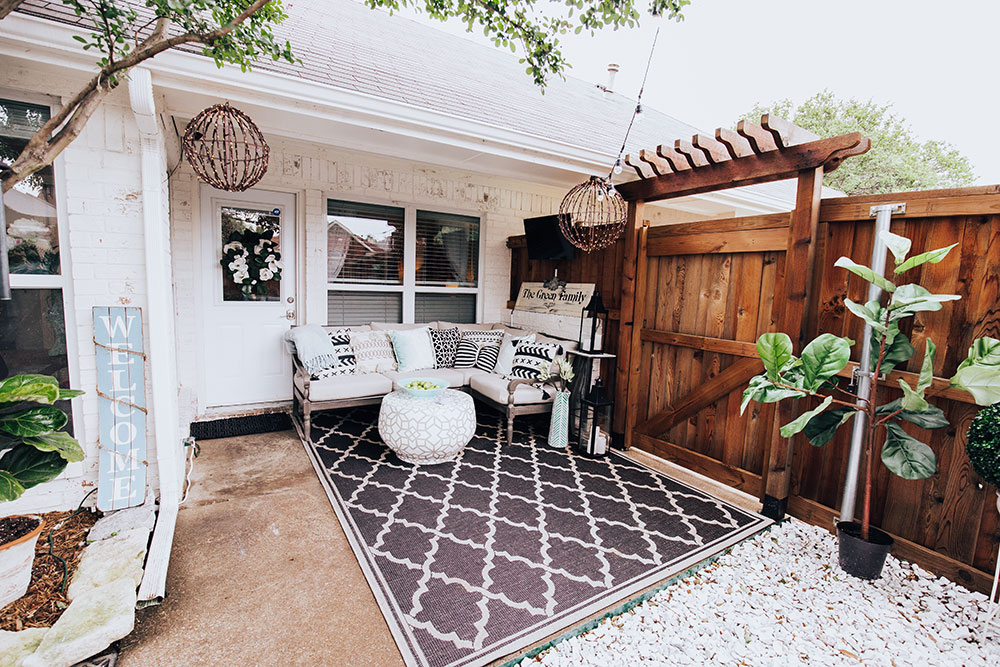 small back porch seating area - black and white outdoor furniture - round hanging orb lights